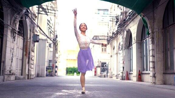 年轻美丽的芭蕾舞演员沿着街道跳舞