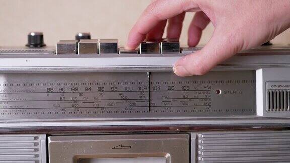 女用手按下带盒式磁带录音机上的播放键变焦
