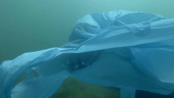 塑料污染一个被丢弃的蓝色塑料袋漂浮在水下里面装着水母水母被困在塑料袋里水下拍摄桶形水母(根口水母)黑海