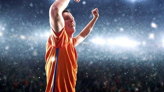 一名足球运动员在下雪的时候在职业球场上高兴地举起手臂庆祝胜利