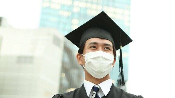 一幅亚洲学生的肖像戴着学士帽穿着学位服庆祝毕业