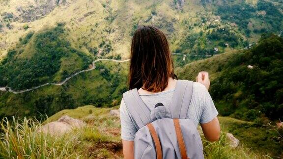 后视图年轻的女游客背着背包走下极其陡峭的山路史诗般的斯里兰卡慢镜头