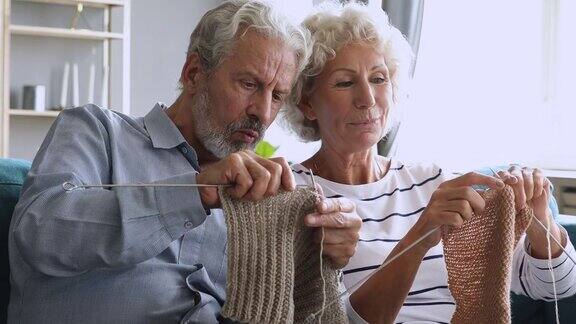老爷爷在家里帮老婆婆学织毛线