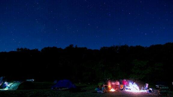 帐篷露营在夜晚星星和银河时间流逝天空旋转空间营火在前景