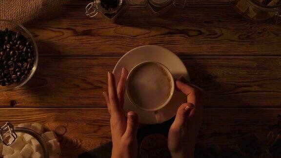 女人手里拿着咖啡杯静静地喝着咖啡和牛奶