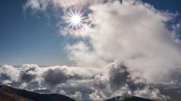 快速的云在蓝天与阳光照耀在美丽的山脉自然时光流逝