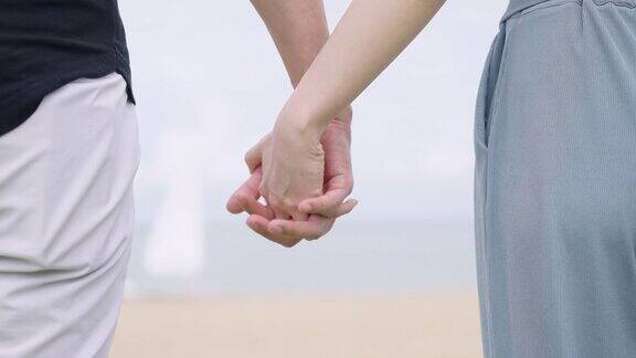 (特写)一对情侣在海滩上手牵手