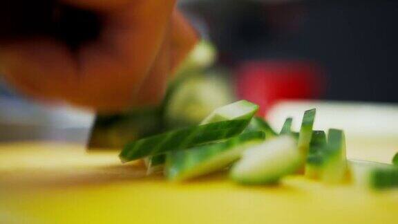 青瓜切成小块一个厨师快速切绿色蔬菜的近景
