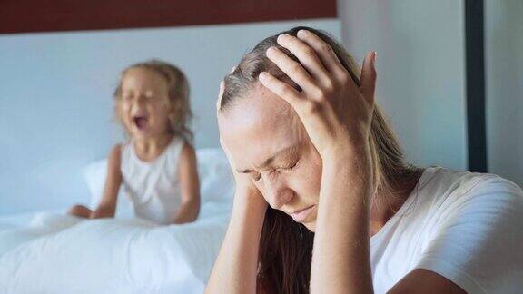 沮丧的母亲和愤怒的孩子尖叫枕头的背景