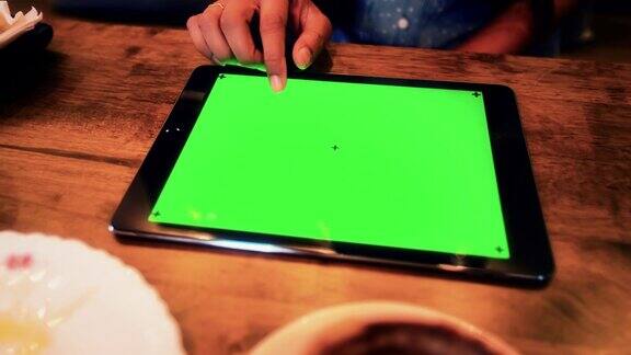 女商人在咖啡厅用平板电脑绿屏