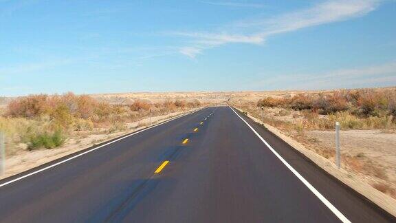 FPV:在美国犹他州的秋天沿着空旷的道路穿过广阔的沙漠