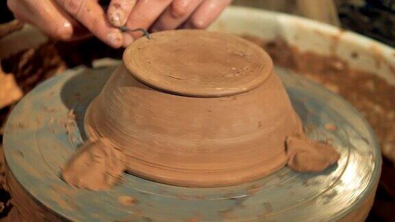 一个陶工雕刻一个新碗的脚
