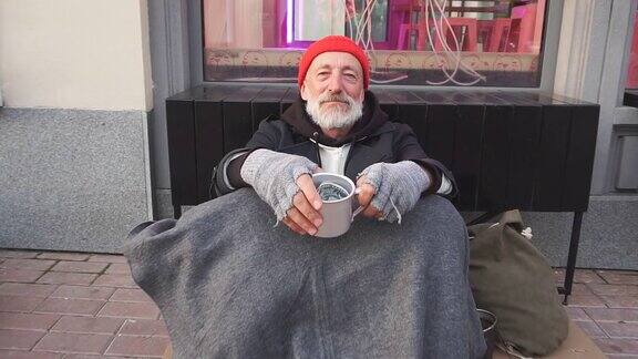在寒冷的天气里那些穿着街头服装、思想开放的无家可归者坐着寻求帮助