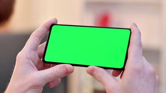 在智能手机的水平绿色色度键屏幕上观看