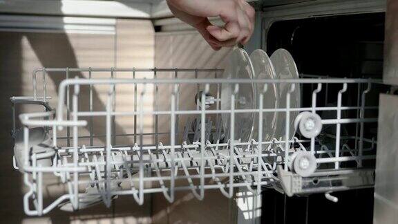 用手从洗碗机中取出干净的餐具