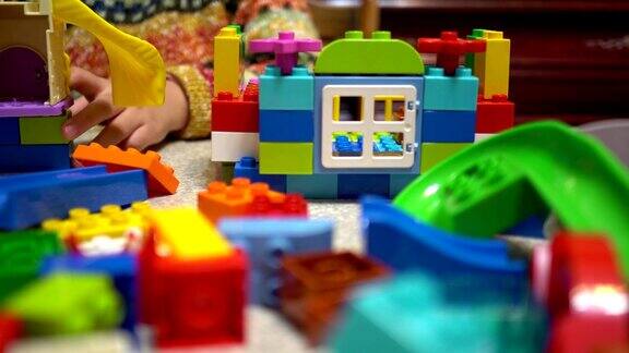 小孩子在室内玩许多五颜六色的塑料玩具