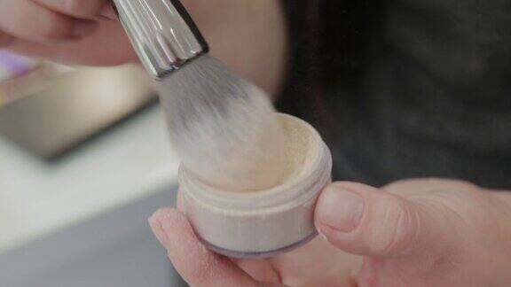 专业的化妆师一名女子用刷子涂粉底