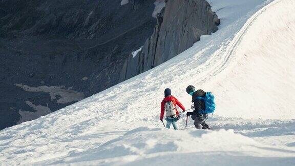 一队登山者正在从陡峭的山峰上下来冬天的风景
