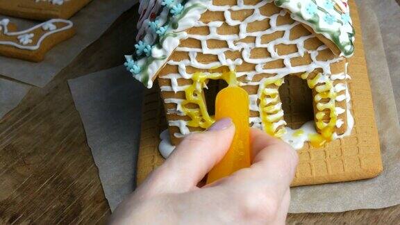 姜饼糖霜厨师的女手用黄糖霜装饰糕饼店用一袋姜饼铺在家里的厨房里新年传统