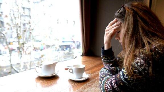 一个沮丧的女人独自坐在café