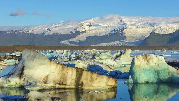 4k时间移动的云与蓝色冰山漂浮在Jokulsarlon冰湖冰岛
