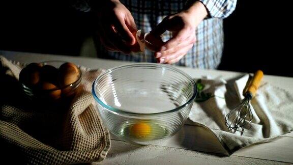 男子用手在碗里打碎鸡蛋厨师在玻璃碗里打鸡蛋