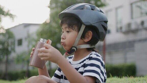 男孩骑完自行车后喝水