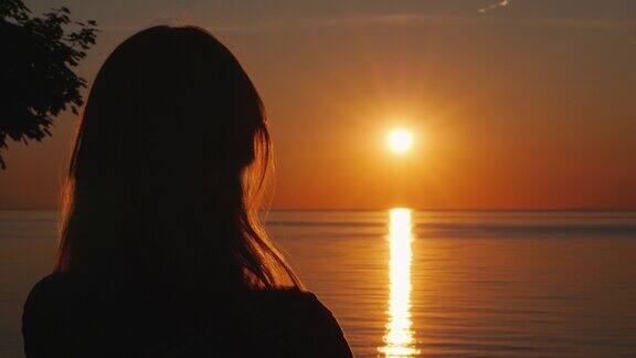 一个中年妇女的剪影谁看日落的海上