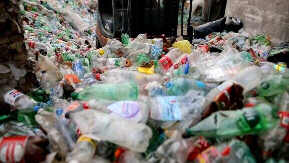 铲车把包装好的塑料瓶堆在一起在一家回收工厂工作