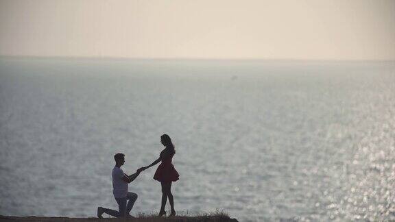 男人向以海景为背景的女人求婚