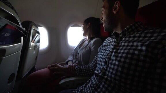 一对夫妇从飞机窗户往外看