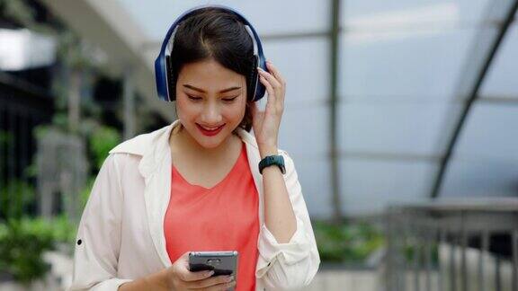微笑的年轻女子戴着耳机听音乐
