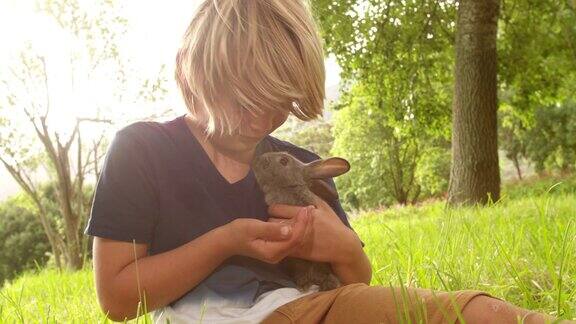 快乐的孩子在外面照顾一只兔子