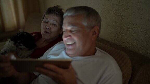 一对老年夫妇在家里用平板电脑视频通话
