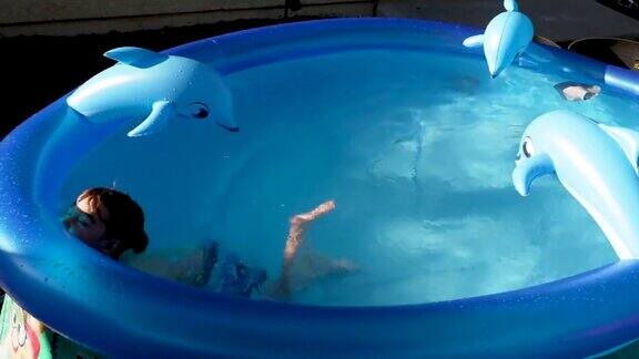 孤独的小男孩在自家后院玩充气游泳池
