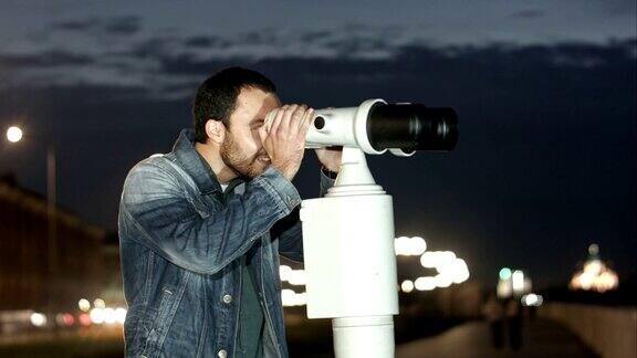 用投币式望远镜欣赏城市美景的人