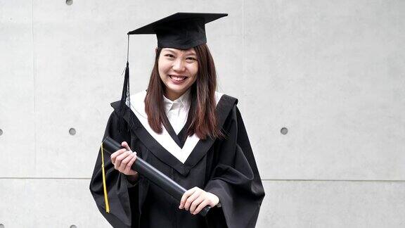 毕业在东亚-年轻女子微笑着长袍和帽子