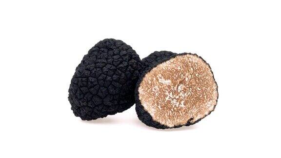 一个完整的黑松露蘑菇和半个黑松露蘑菇白色背景