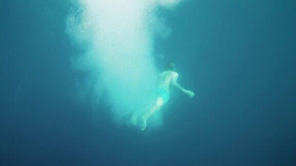 男子跳入水中游泳的水下镜头在海洋中潜水