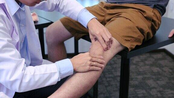 亚洲理疗师正在检查患者的膝盖