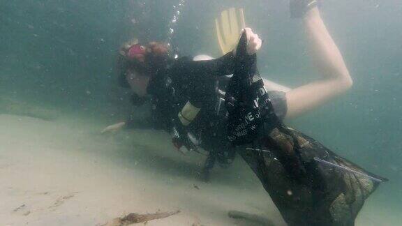 年轻女子潜水对抗残骸水下垃圾清理