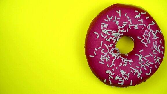 美味的甜甜圈在盘子里旋转前视图明亮和彩色的喷洒甜甜圈特写微距镜头旋转在黄色的背景