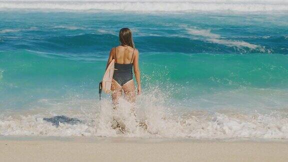 迷人的女人在海滩冲浪