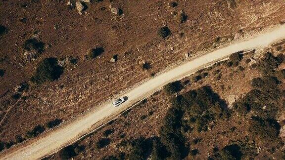 俯视图白色汽车吉普车行驶在山区公路沿着荒野