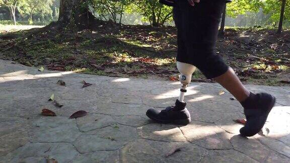 一位亚洲印度女性戴着假肢在周末早上在公园散步和锻炼