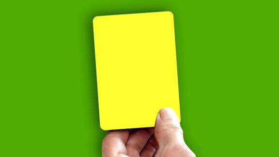 手在绿色屏幕上显示黄牌