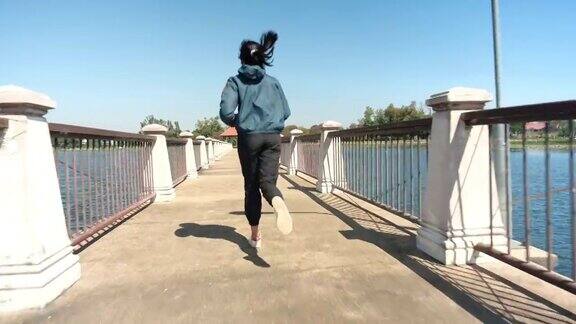 运动的女人在桥上慢跑