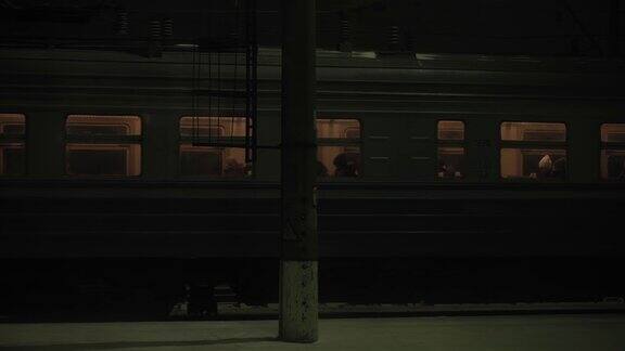 交通、道路、铁路、景观、交通、概念夜深人静时站在火车站上火车的人从窗口看到的景象在下雪的冬天乘火车去乡村旅行