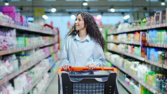 快乐的年轻黑发女子购物车在超市购物走在大卖场推着手推车去买买买