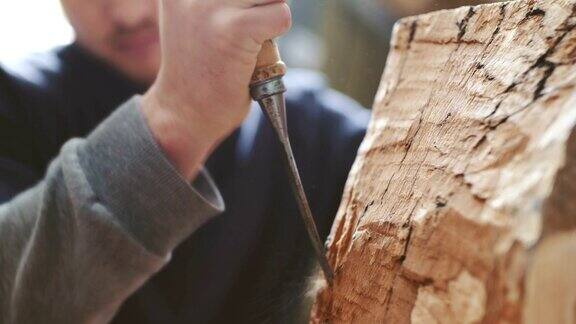 年轻的木匠用凿子雕刻木头